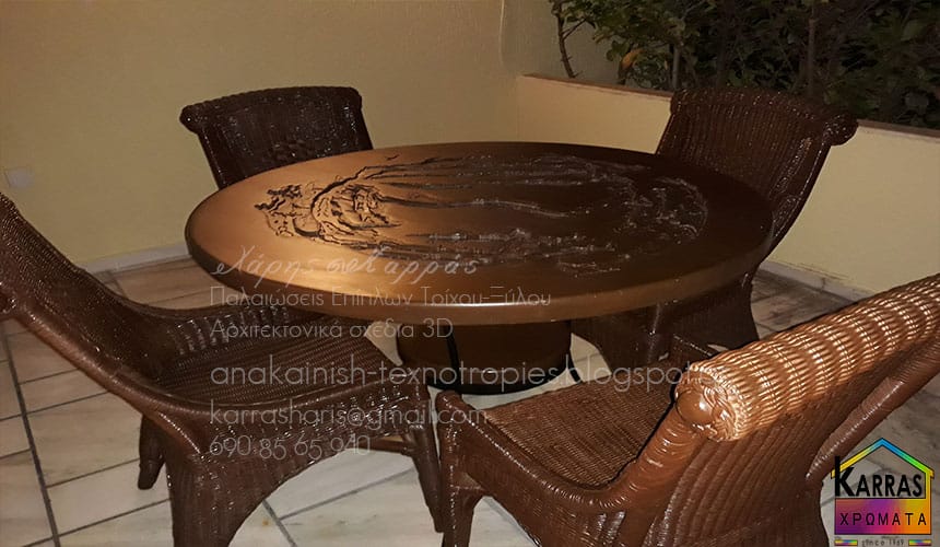 Στρογγυλό τραπέζι με μεταλλικά πόδια και καρέκλες από ψάθα σε εσωτερικό χώρο.